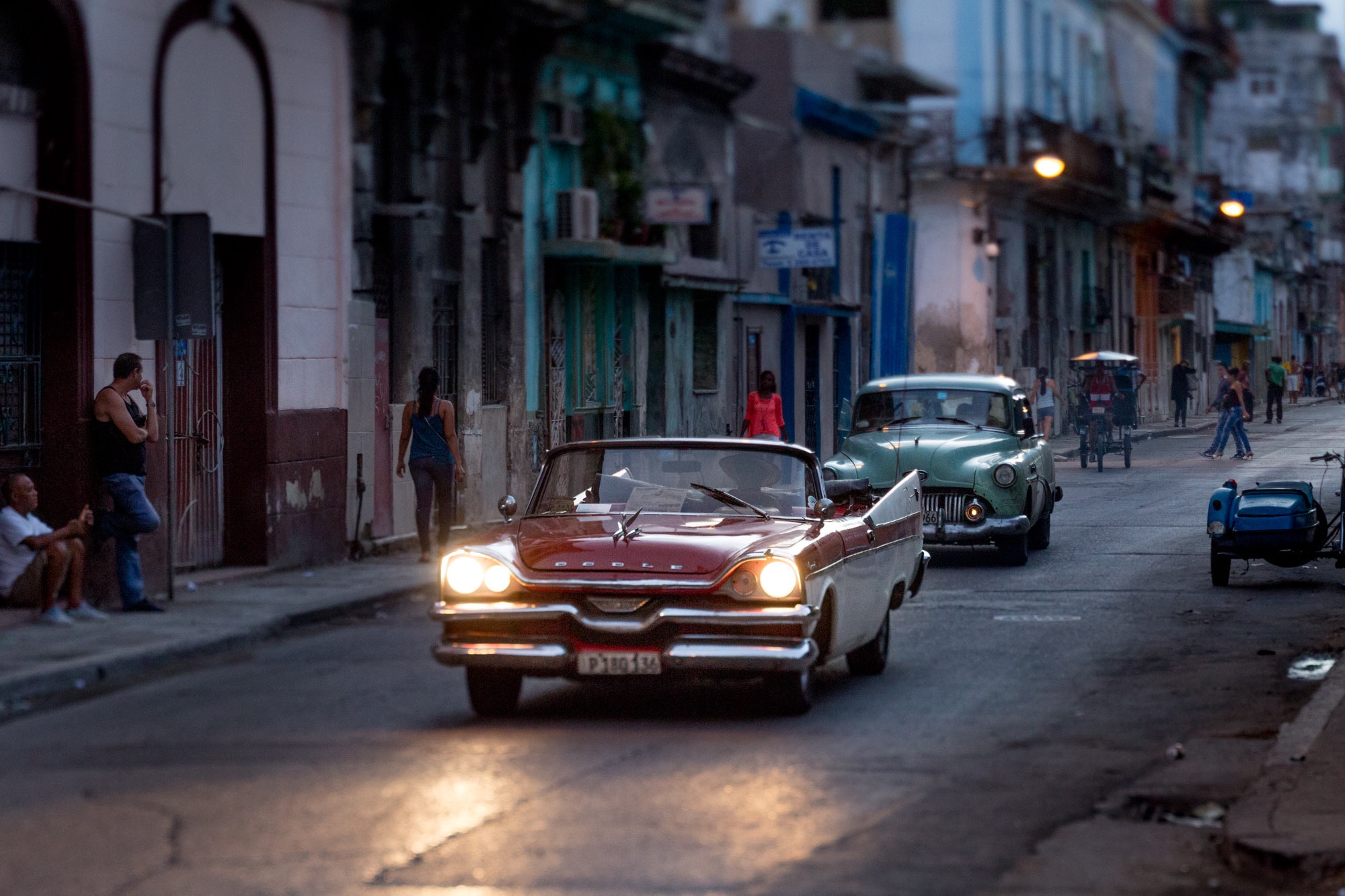 A classic car driving in a sexy part of Havana.