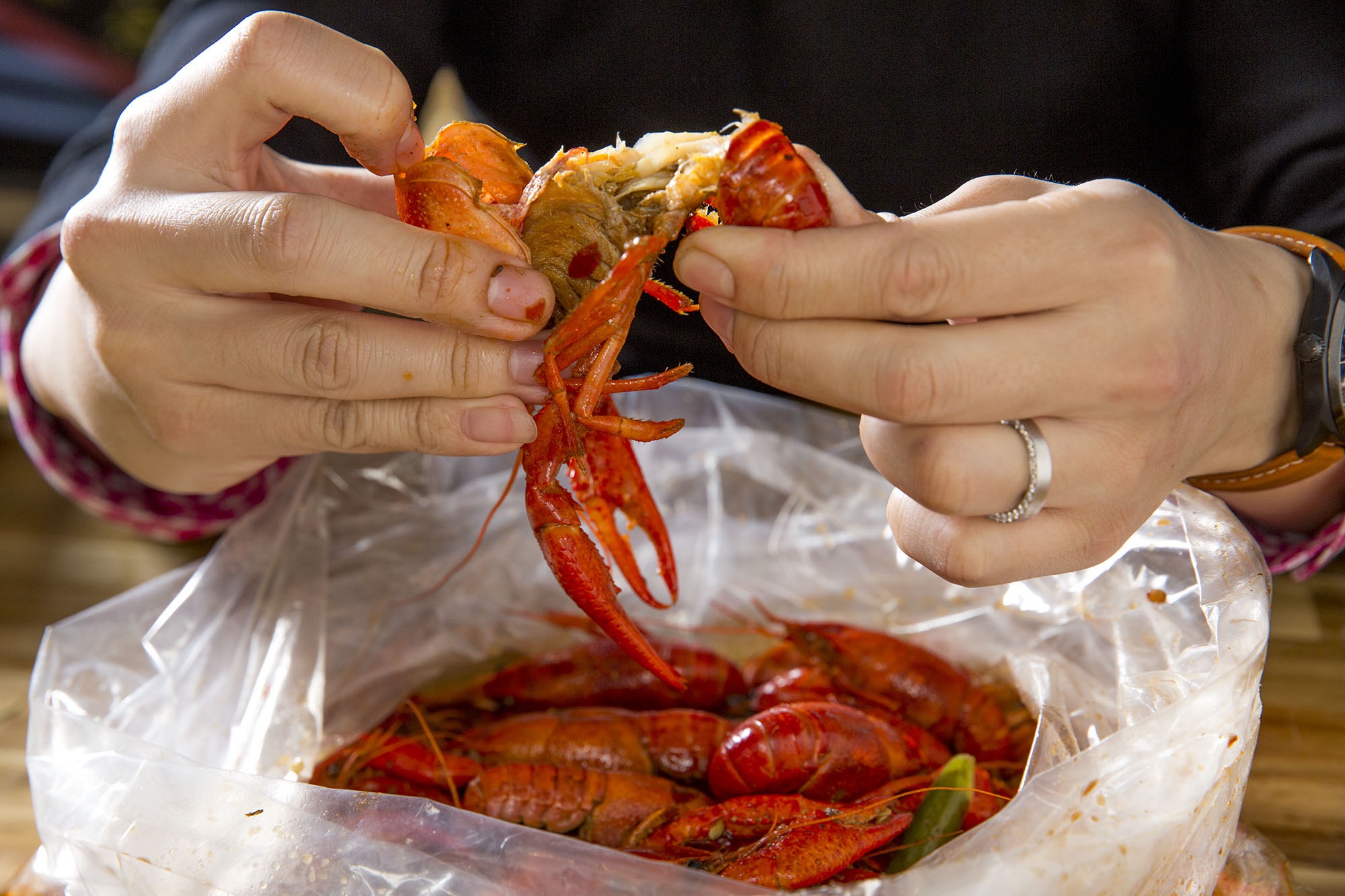 Hands pulling apart seafood.
