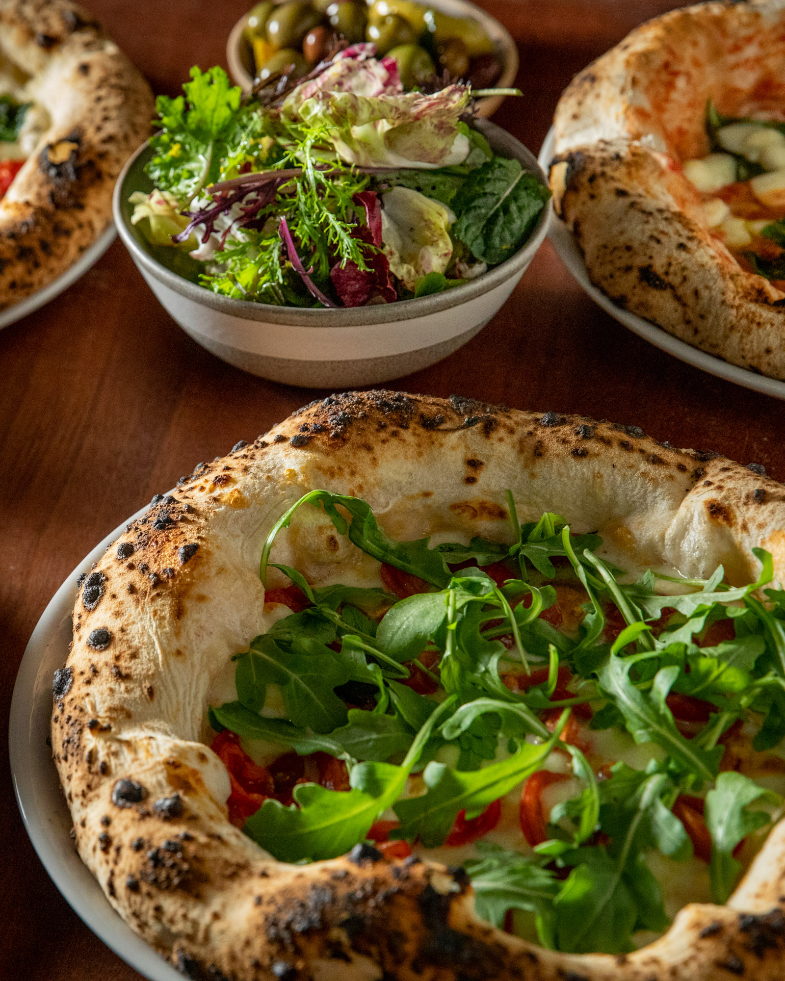 A group of food dishes with moody light at a restaurant.