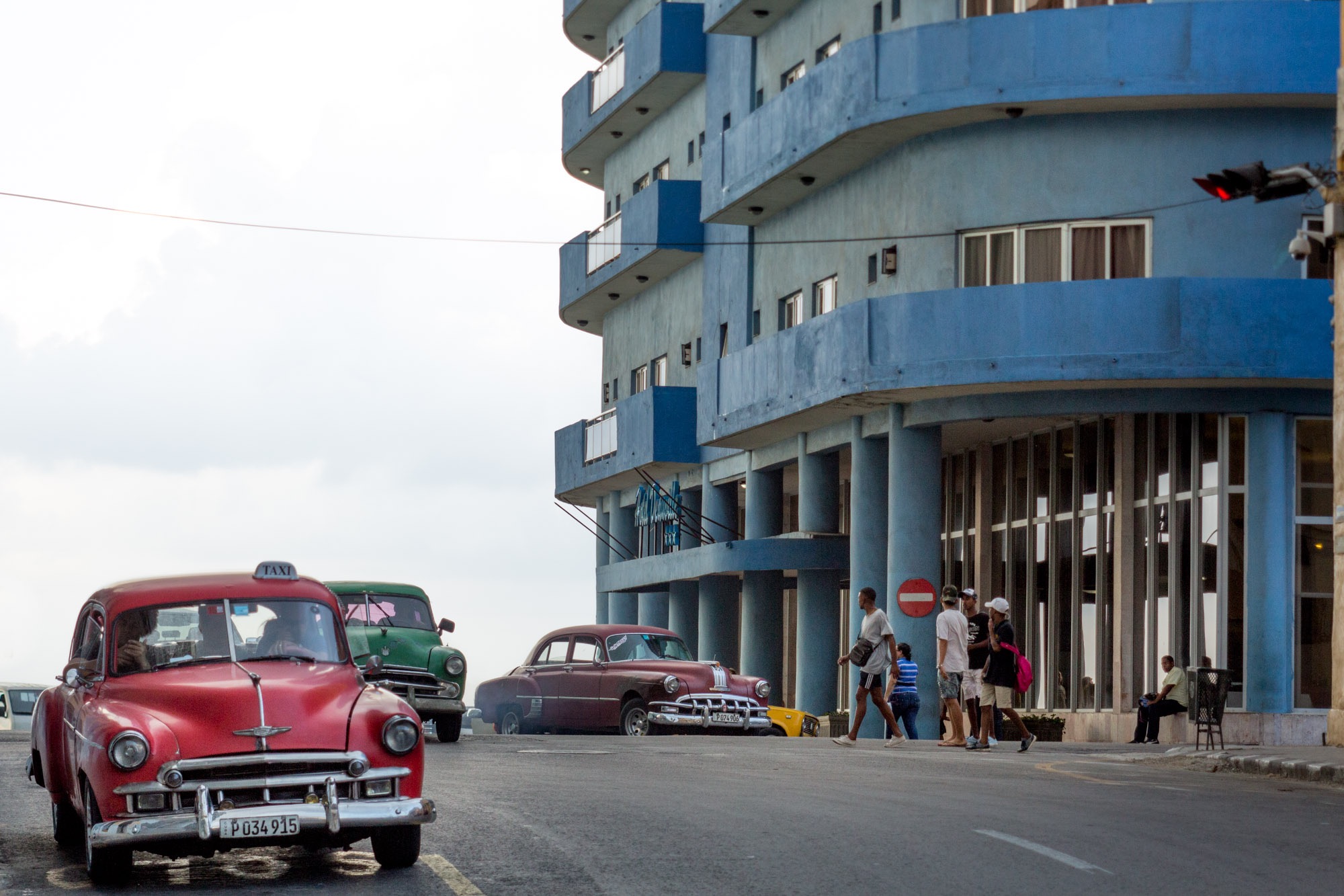 An old fashioned car parked outside a hotel in Cuba.