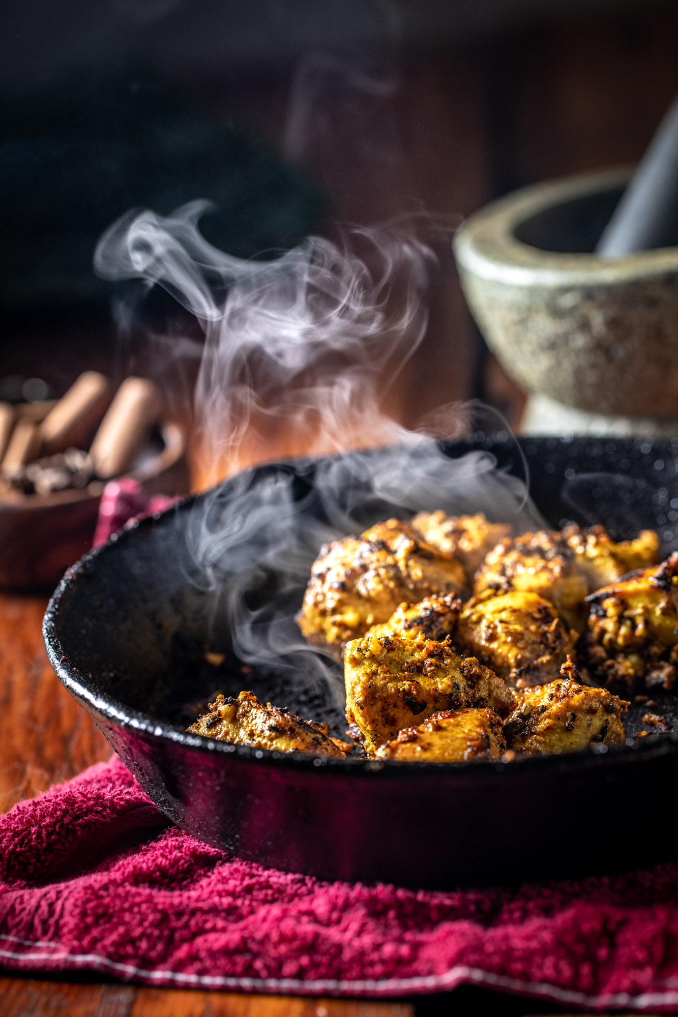 beauty hero shot of chicken tikka simmering in a skillet and steaming.