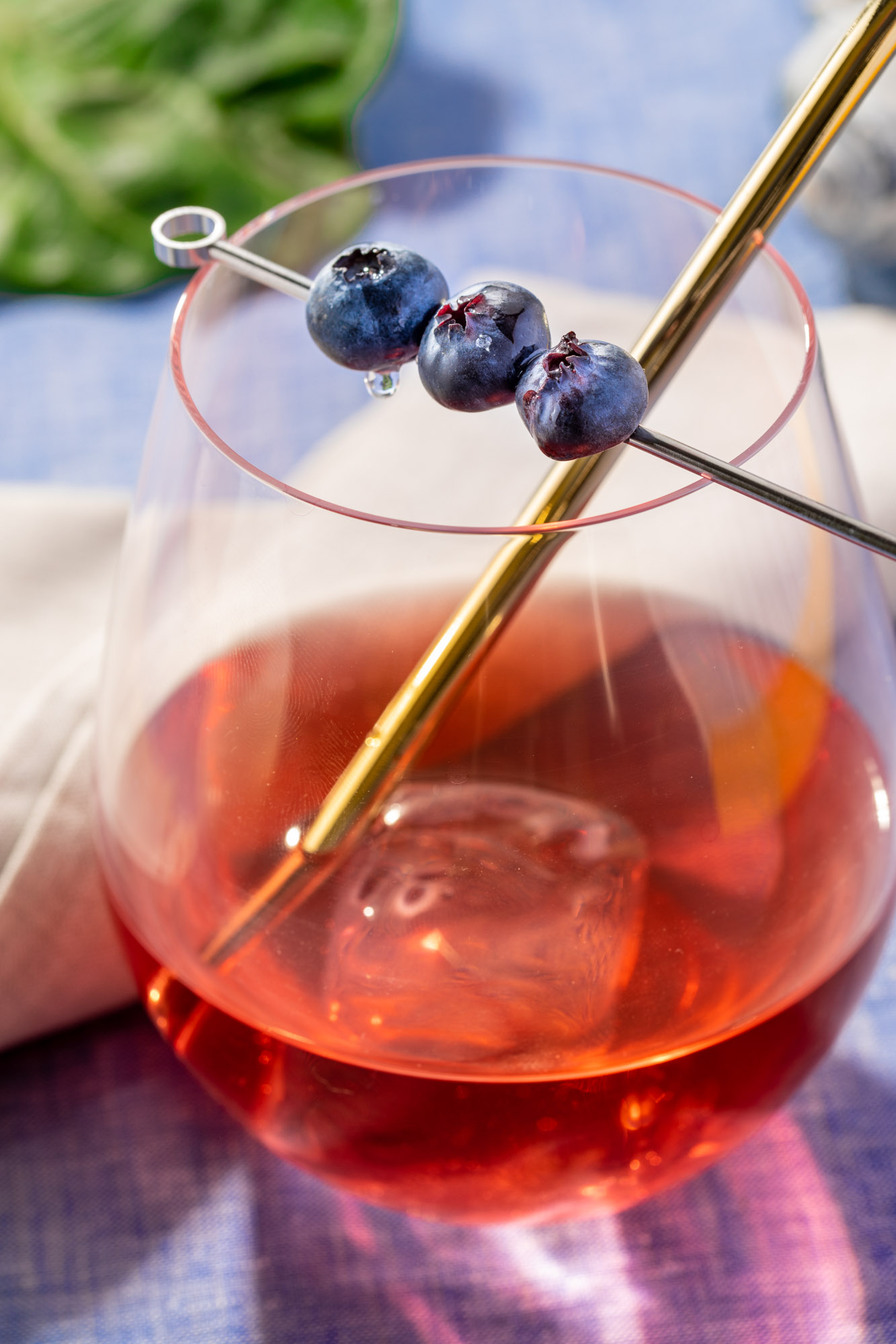 A cocktail with a blueberry garnish
