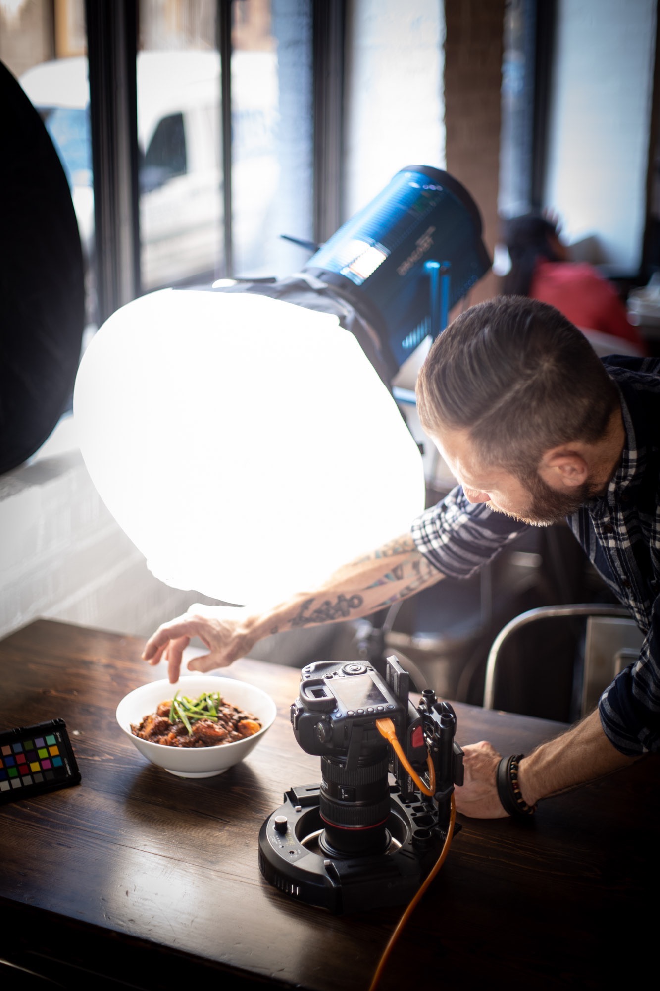 A chef food styling his food for a photoshoot