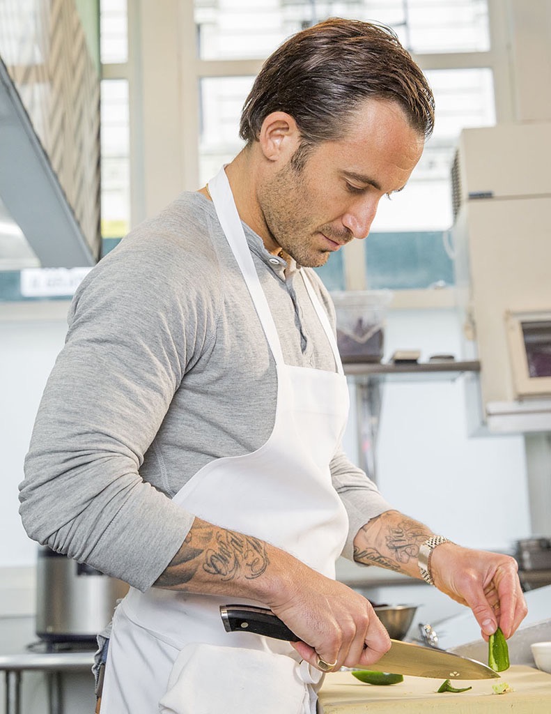 A chef prepping food in the kitchen of his restaurant