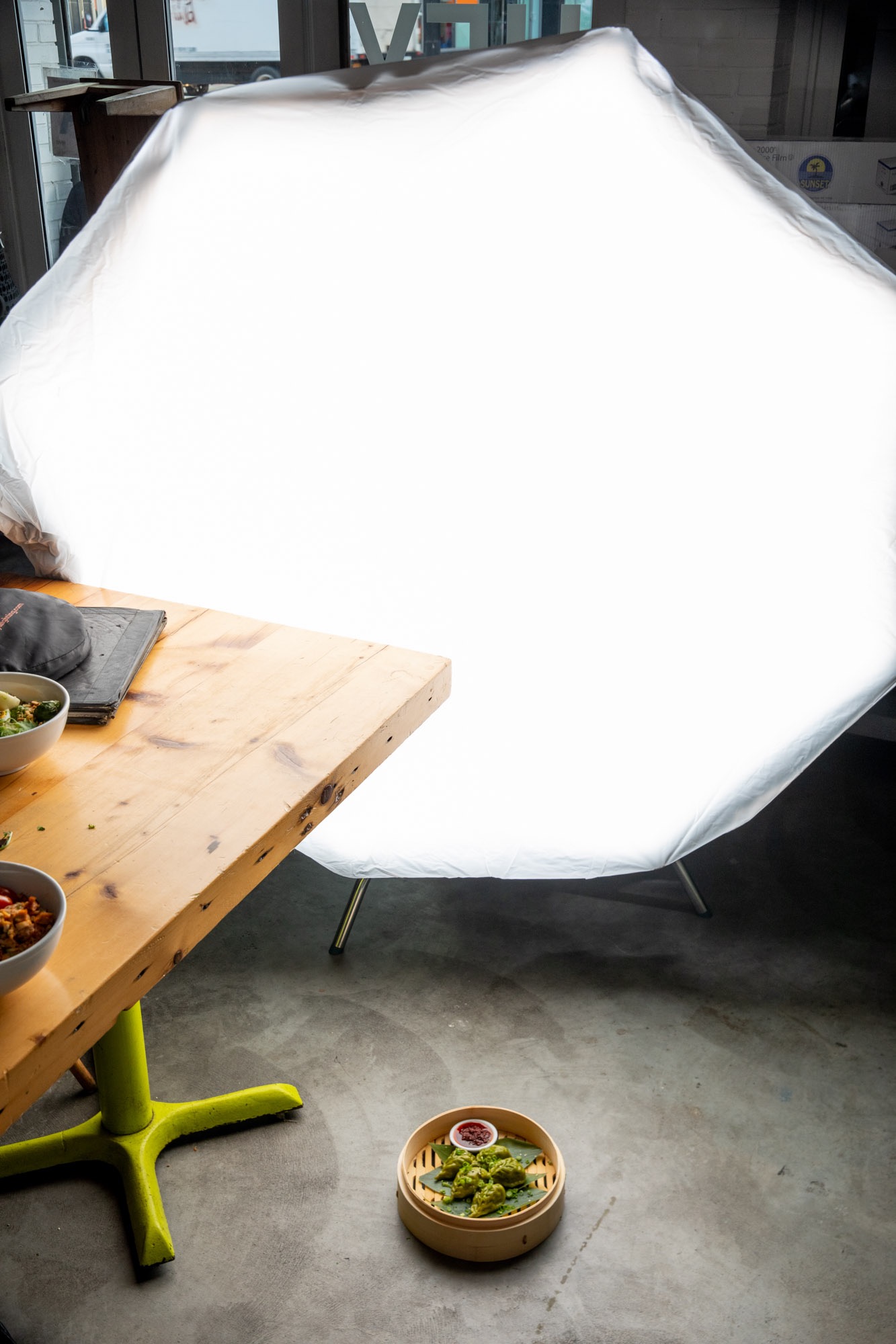 A bambo steaming basket being photographed with a large photo light