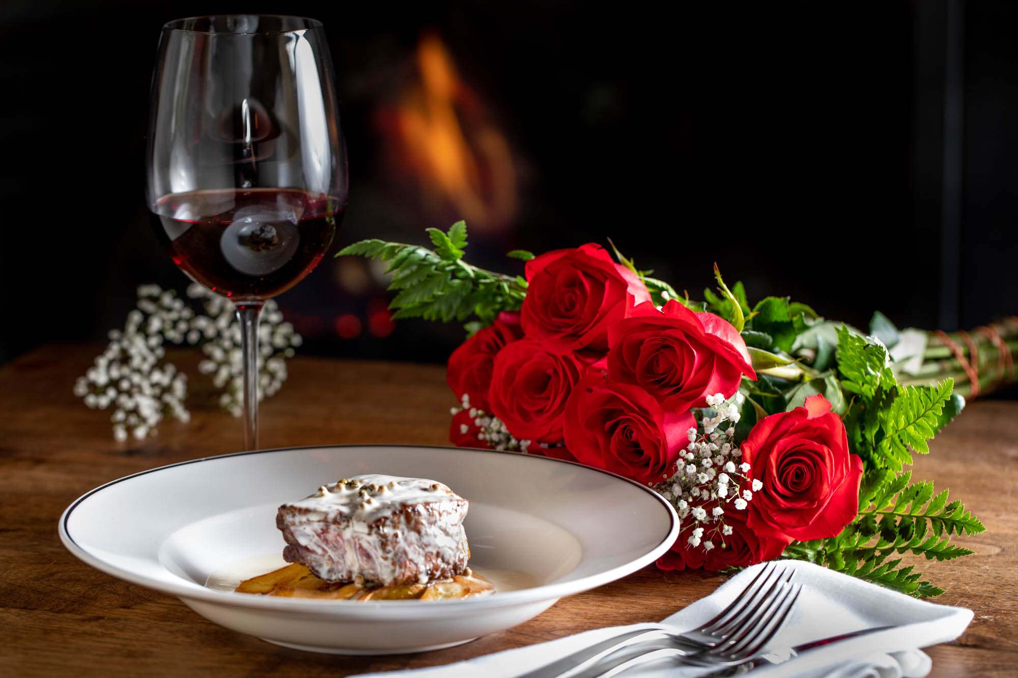 A romantic dish of food and a dozen roses photographed for Valentines Day.