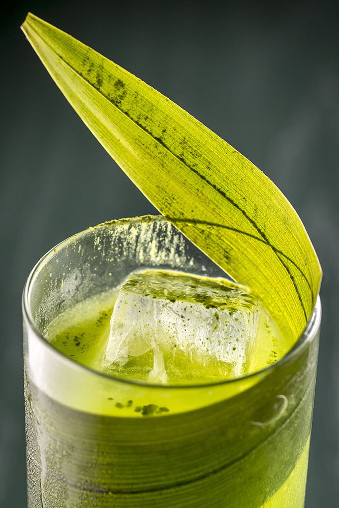 A cocktail made with matcha glowing with light