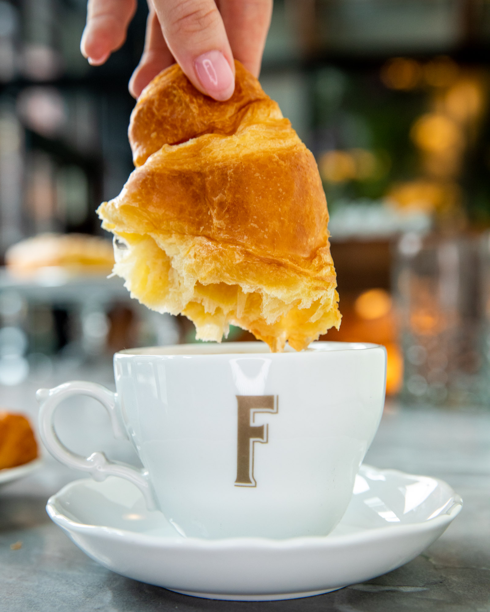 Croissant being dipped in a cup of coffee
