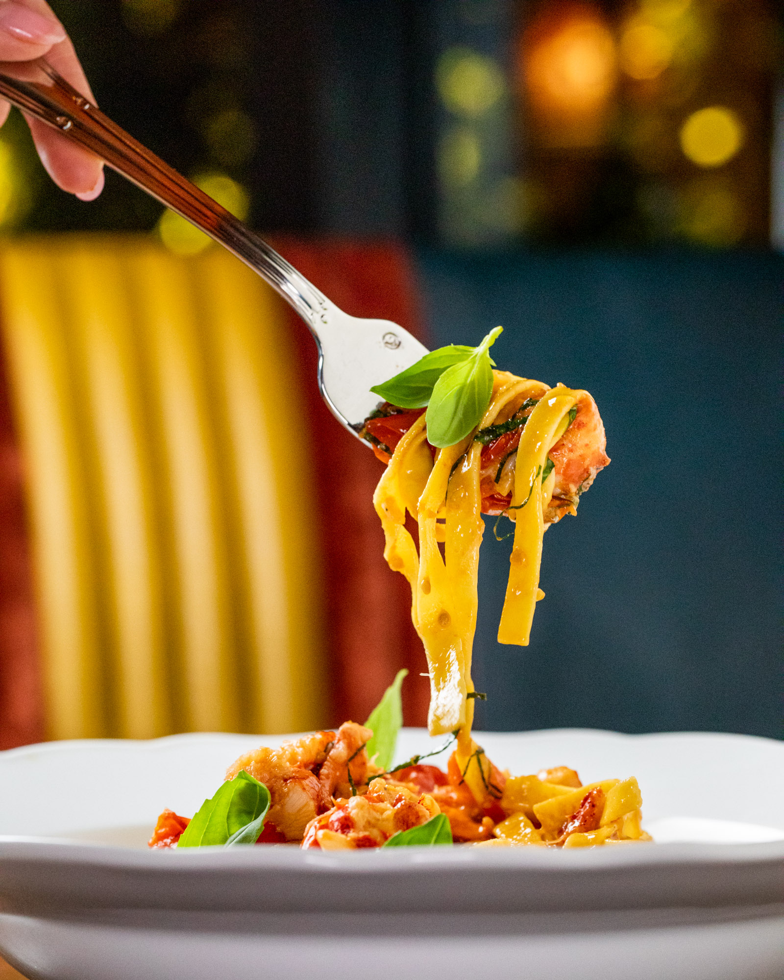 A fork with linguine on it being lifted to the sky