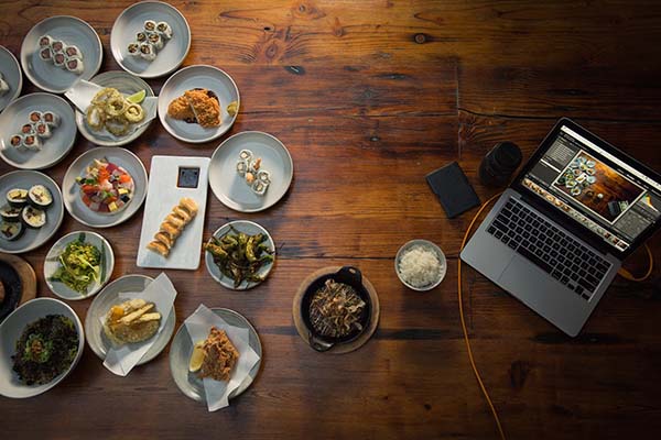 A lot of plates of food and a laptop