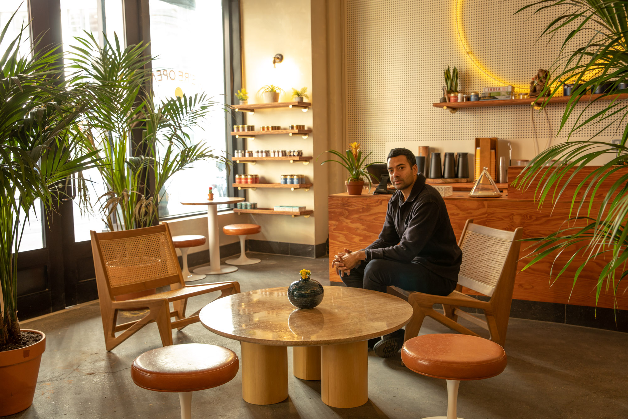 The owner of a restaurant posing for a portrait in his newly updated interior